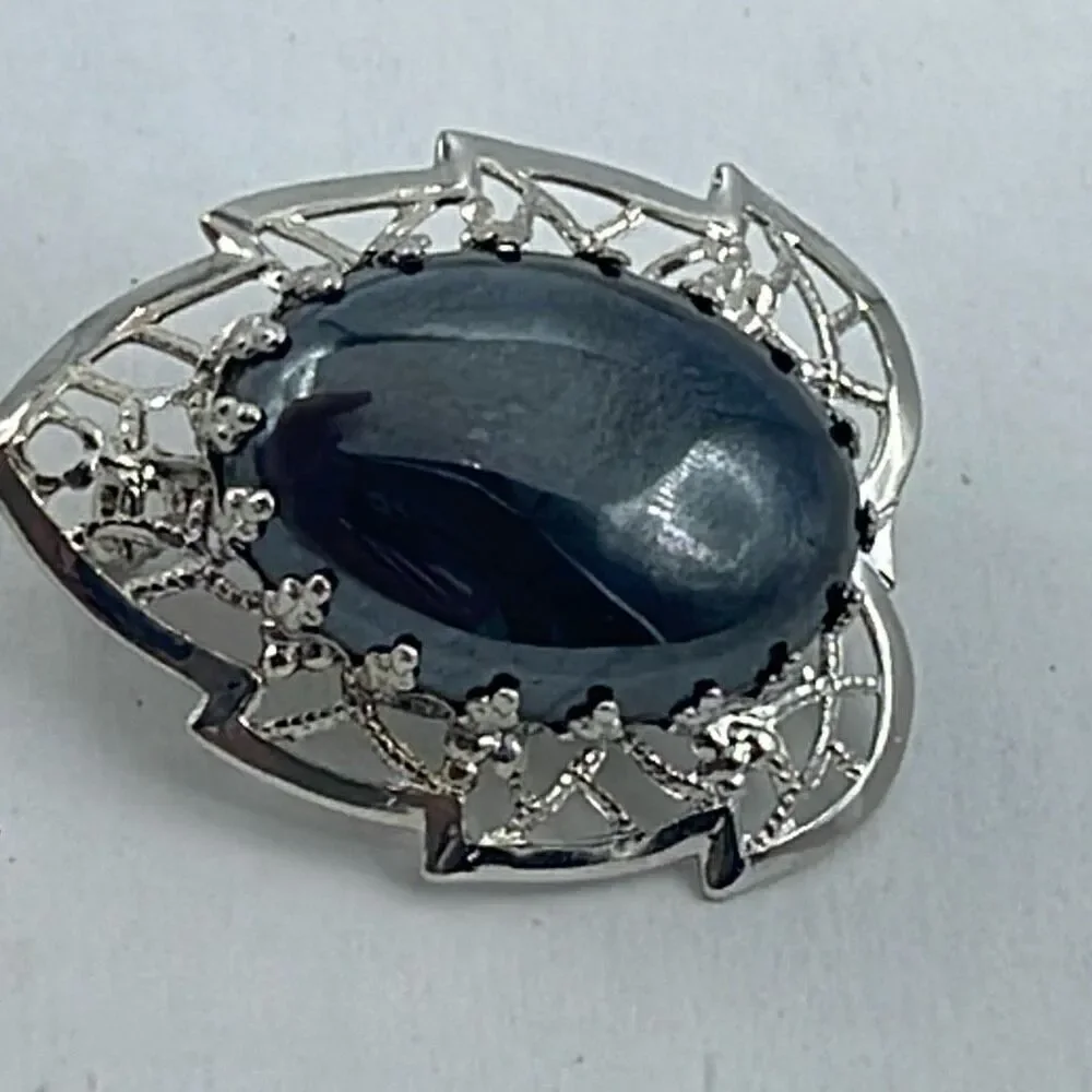 Vintage filigree framed hematite brooch.